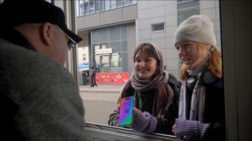 Zwei Studentinnen erkundigen sich bei Herrn Werdermann im ZOB-Häuschen, wo ihr Bus abfährt.